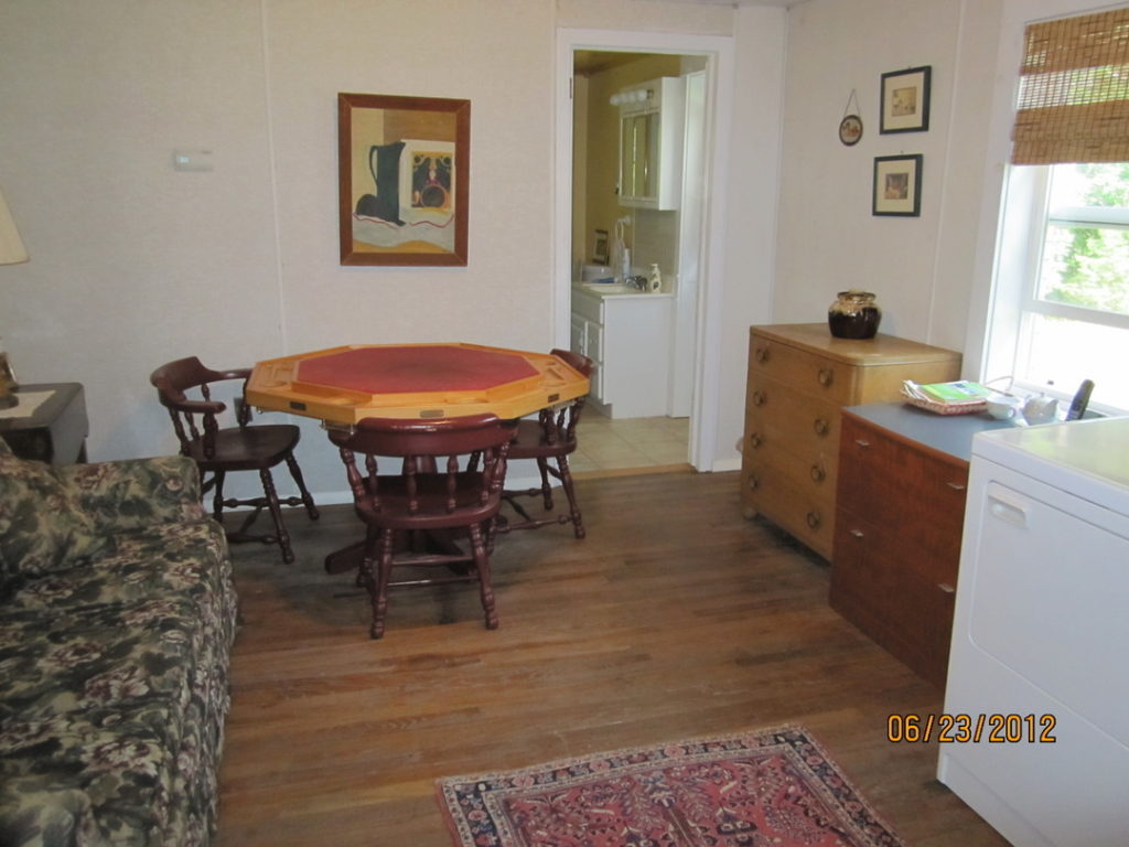The back room with washer, dryer, poker table, and couch. Leads to bathroom