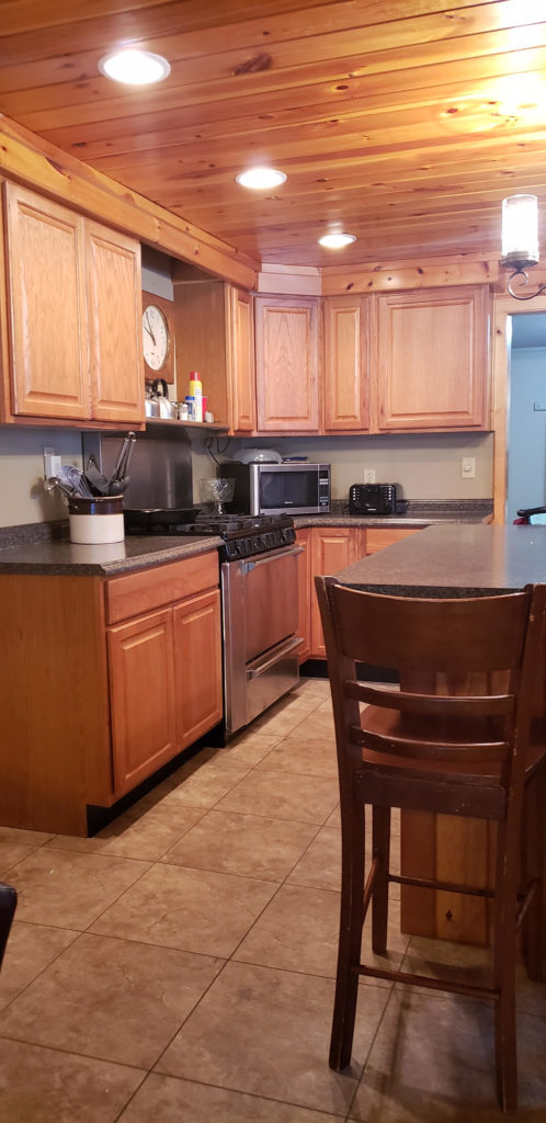 Kitchen showing island, cabinets, and stove