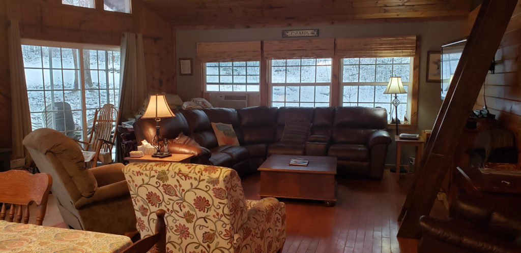 Living Room with couch, 3 chairs, TV, and fold-away ladder to loft